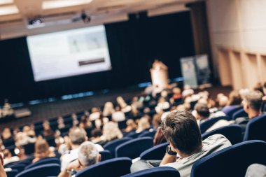 Konuşmacı bilimsel konferans hakkında bir konuşma yapacak. Konferans salonundaki izleyiciler. İş ve Girişimcilik kavramı