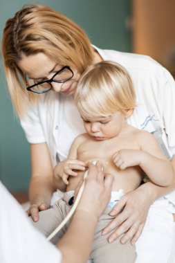 Küçük bir çocuk kalp üfürümü için kalp ultrasonu ile kardiyolog tarafından çocuk doktoruna düzenli olarak muayene ediliyor.