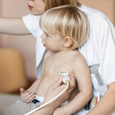 Küçük bir çocuk kalp üfürümü için kalp ultrasonu ile kardiyolog tarafından çocuk doktoruna düzenli olarak muayene ediliyor.