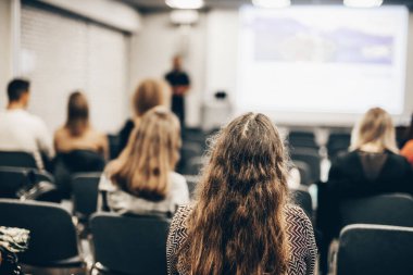 Sözcü, iş konferansında konferans salonunda konuşma yapacak. Konferans salonundaki tanınmayan insanların arka görüntüsü. İş ve girişimcilik kavramı
