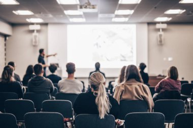 Sözcü, iş konferansında konferans salonunda konuşma yapacak. Konferans salonundaki tanınmayan insanların arka görüntüsü. İş ve girişimcilik kavramı