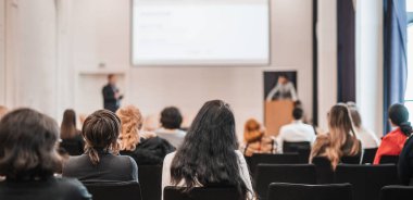 Sözcü, iş konferansında konferans salonunda konuşma yapacak. Konferans salonundaki tanınmayan insanların arka görüntüsü. İş ve girişimcilik kavramı