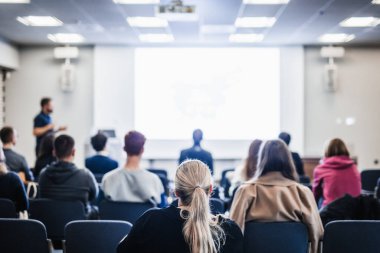 Sözcü, iş konferansında konferans salonunda konuşma yapacak. Konferans salonundaki tanınmayan insanların arka görüntüsü. İş ve girişimcilik kavramı