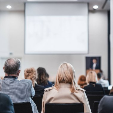 Sözcü, iş konferansında konferans salonunda konuşma yapacak. Konferans salonundaki tanınmayan insanların arka görüntüsü. İş ve girişimcilik kavramı