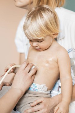 Küçük bir çocuk kalp üfürümü için kalp ultrasonu ile kardiyolog tarafından çocuk doktoruna düzenli olarak muayene ediliyor.