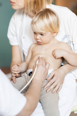 Küçük bir çocuk kalp üfürümü için kalp ultrasonu ile kardiyolog tarafından çocuk doktoruna düzenli olarak muayene ediliyor.