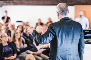 Kamu Sunumlarıyla İş Konferansı Sözcüsü. Konferans salonundaki izleyiciler. Girişimcilik Kulübü 'ne. Dikiz aynası. Horisontal kompozisyon. Arkaplan bulanıklığı.