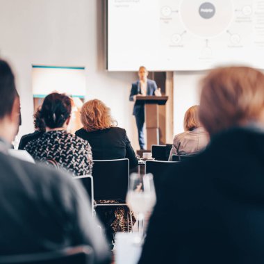 Sözcü, iş konferansında konferans salonunda konuşma yapacak. Konferans salonundaki tanınmayan insanların arka görüntüsü. İş ve girişimcilik kavramı