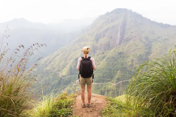 Etkin Beyaz sarışın kadın enjoing temiz hava ve bozulmamış doğa çay plantaitons arasında izleme sırasında Ella, Sri Lanka yakın. Bacpecking açık havada turist macera.