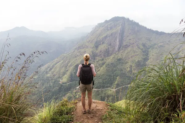 Etkin Beyaz sarışın kadın enjoing temiz hava ve bozulmamış doğa çay plantaitons arasında izleme sırasında Ella, Sri Lanka yakın. Bacpecking açık havada turist macera.