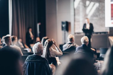 Sözcü, iş konferansında konferans salonunda konuşma yapacak. Konferans salonundaki tanınmayan insanların arka görüntüsü. İş ve girişimcilik kavramı