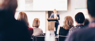 Sözcü, iş konferansında konferans salonunda konuşma yapacak. Konferans salonundaki tanınmayan insanların arka görüntüsü. İş ve girişimcilik kavramı