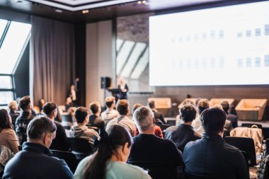 Kadın konuşmacı şirket iş konferansı hakkında bir konuşma yapıyor. Konferans salonundaki tanınmayan insanlar. İş ve Girişimcilik etkinliği