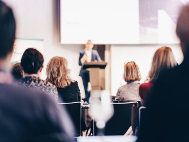 Sözcü, iş konferansında konferans salonunda konuşma yapacak. Konferans salonundaki tanınmayan insanların arka görüntüsü. İş ve girişimcilik kavramı