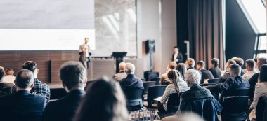 Sözcü, iş konferansında konferans salonunda konuşma yapacak. Konferans salonundaki tanınmayan insanların arka görüntüsü. İş ve girişimcilik kavramı