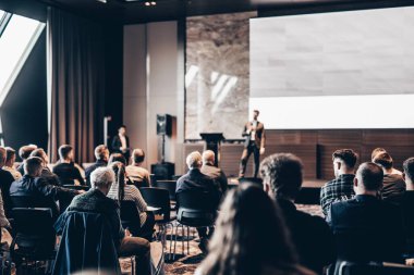 Sözcü, iş konferansında konferans salonunda konuşma yapacak. Konferans salonundaki tanınmayan insanların arka görüntüsü. İş ve girişimcilik kavramı