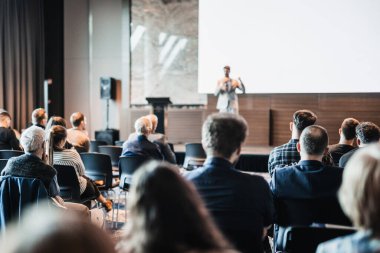 Sözcü, iş konferansında konferans salonunda konuşma yapacak. Konferans salonundaki tanınmayan insanların arka görüntüsü. İş ve girişimcilik kavramı