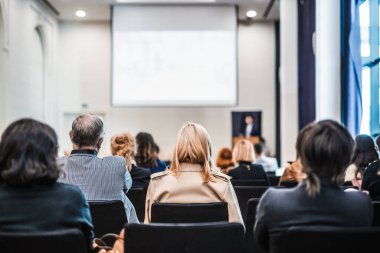 Sözcü, iş konferansında konferans salonunda konuşma yapacak. Konferans salonundaki tanınmayan insanların arka görüntüsü. İş ve girişimcilik kavramı