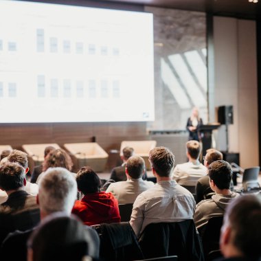 Kadın konuşmacı şirket iş konferansı hakkında bir konuşma yapıyor. Konferans salonundaki tanınmayan insanlar. İş ve Girişimcilik etkinliği
