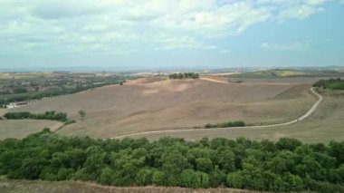 Güneş doğarken insansız hava aracı ile Toskana kırsalında çekilmiş. Çiftlik evi, tepeler, tarlalar, üzüm bağları, yol boyunca selvi ağaçları. 4k