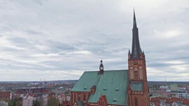 Szczecin Katedrali. Önünde beyaz haç ve ağaçlar olan katedralin manzarası. Aziz Havari James 'in Katedral Bazilikası. Yüksek kalite 4k görüntü.
