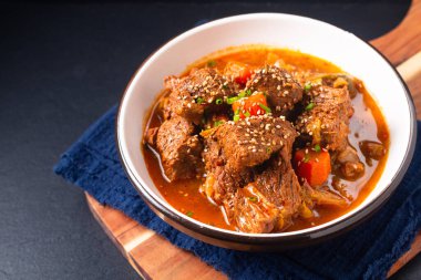Fotokopi alanı olan siyah arka planda Kore baharatlı biftek yahnisi.