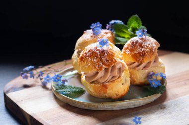 Gıda konsepti Benekli ev yapımı Choux puff Praline fotokopi alanı ile siyah arkaplan üzerine