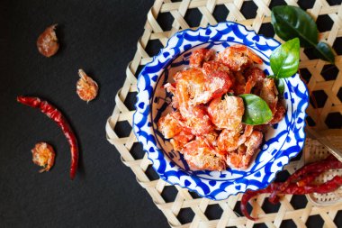 Geleneksel tepside kurutulmuş karides kavramı. Siyah arka planda fotokopi alanı olan kaidesi var.