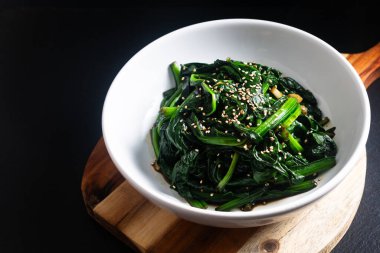 Gıda konsepti Benekli Kore Ispanak Salatası siyah arkaplan üzerine fotokopi alanı