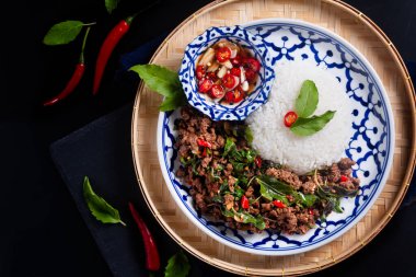 Tayland usulü otantik Khao Pad kra pao pilavı ve siyah arka planda Tayland usulü Basil bifteği kızartması.
