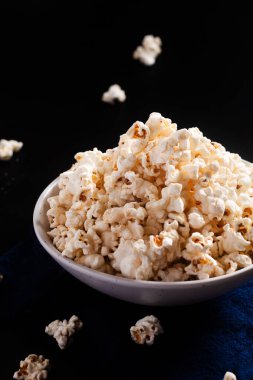 Gıda kavramı seramik kasede patlamış mısır siyah arka planda fotokopi alanı ile