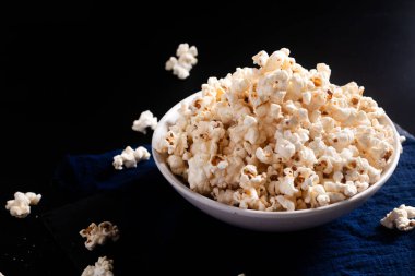 Gıda kavramı seramik kasede patlamış mısır siyah arka planda fotokopi alanı ile