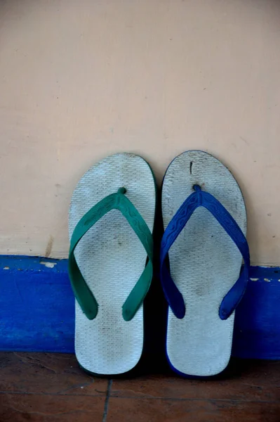 Duvarda Kullanılmış Mavi Yeşil Parmak Arası Terlikler — Stok fotoğraf