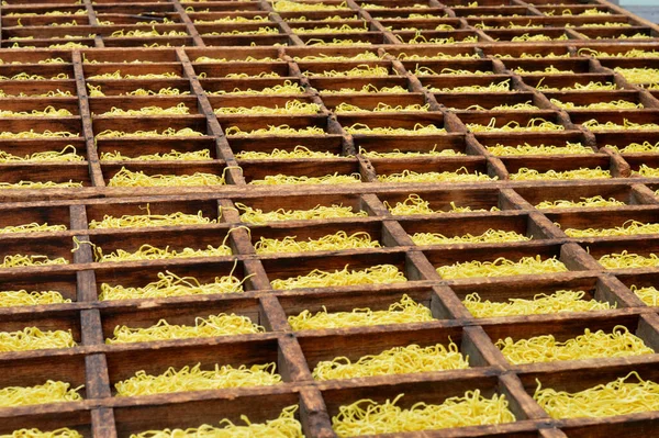 Processo Secagem Macarrão Amarelo Uma Caixa Madeira — Fotografia de Stock