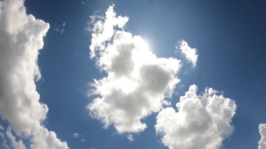Güneş parlarken mavi gökyüzünde beyaz bulutların 4K perdesi