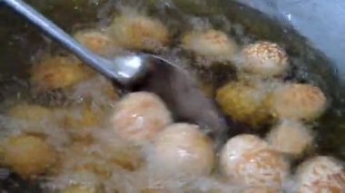 Kızartma işlemi susam tohumu topları ya da Onde-onde. Endonezya geleneksel sokak yemekleri