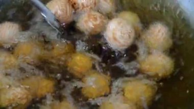 Kızartma işlemi susam tohumu topları ya da Onde-onde. Endonezya geleneksel sokak yemekleri