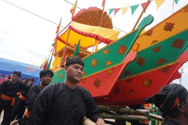 Tarakan - Indonesia, 22 October 2022 : Boat containing offerings that will be floated out to sea during the Iraw Tengkayu festival in the Ratu Intan Beach area, Tarakan Amal Beach                              clipart