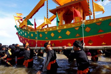 Tarakan - Indonesia, 22 October 2022 : banning procession boat containing offerings out to sea during the Iraw Tengkayu festival in the Ratu Intan Beach area, Tarakan Amal Beach                              clipart