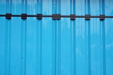 Parlak mavi kıvrımlı metal bir yüzey ve belirgin siyah bağlama klipsleri. Çeşitli tasarım ihtiyaçları için mükemmel, güçlü, modern bir yapısı olan temiz ve endüstriyel bir zemin sunar..