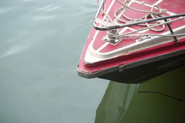 Boat bow with ropes floating on calm waters creates a tranquil scene for summer adventures, holidays, and peaceful relaxation.