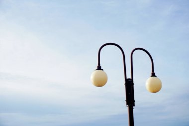 Serene dual lamppost stands against a softly hued sky, offering a clean, modern aesthetic perfect for conveying tranquility and urban design elements. Ideal for lifestyle and architectural concepts.