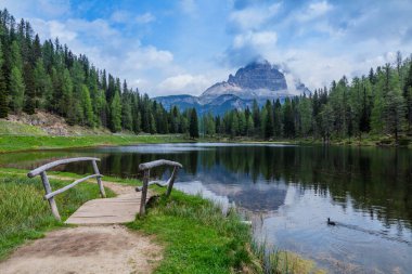İtalya, Bolzano, Güney Tyrol, İtalya 'da Dolomitler' de kırsal köprüsü olan mavi göl. Arka planda Göl ve Dolomitlerin manzarası