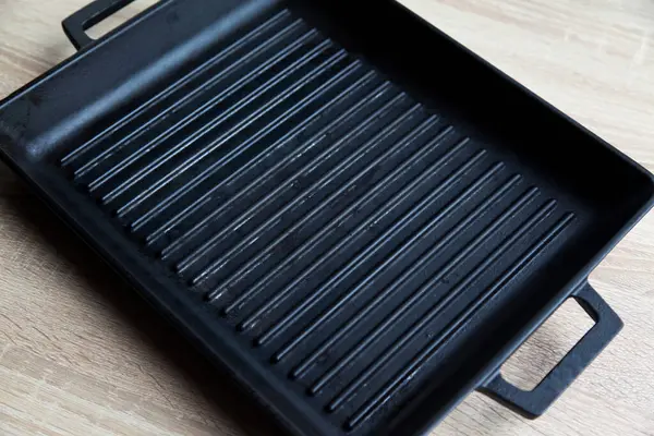 空の黒キャスト重い鉄グリルパン上のモダンなオークキッチンカウンター モダンなキッチン機器 — ストック写真