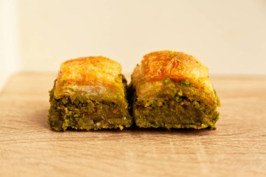 Şam fıstıklı Baklava, Türk mutfağının en güzel tatlılarından biri, Türk tatlı baklavası, meşe ağacından kesme tahtasında.