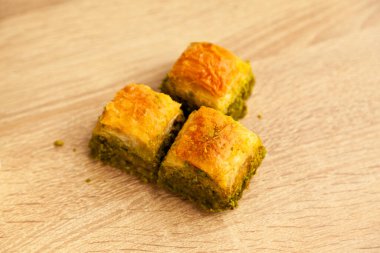 Şam fıstıklı Baklava, Türk mutfağının en güzel tatlılarından biri, Türk tatlı baklavası, meşe ağacından kesme tahtasında.