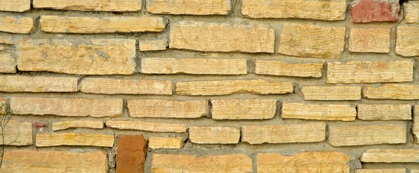 頑丈な黄色とベージュのカット石の壁 背景のために良い シームレスに並んで — ストック写真