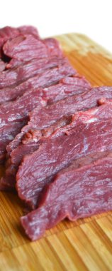 Çok taze kırmızı çiğ inek eti, bambu kesim tahtası, inek eti dokusu.