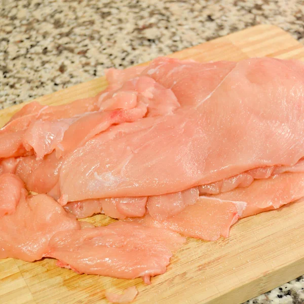 新鮮な生の鶏の肉の胸肉片 調理する準備ができて まな板に — ストック写真