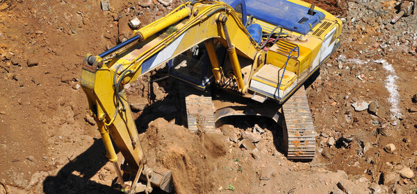 Экскаватор продолжает работу на строительной площадке, на раскопках и экскаваторе 